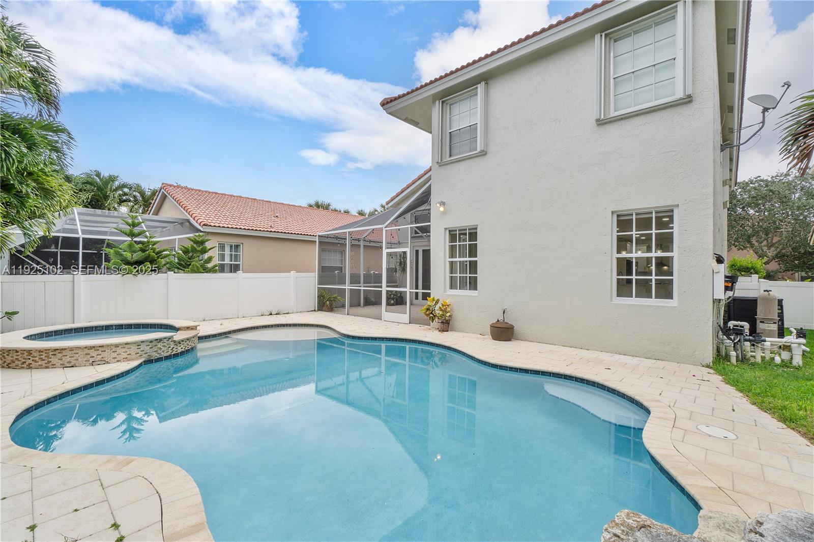 5310 Northwest 124th Way Coral Springs, FL 33076 - Photo 24 of 30 a view of a white house with a swimming pool and sitting area