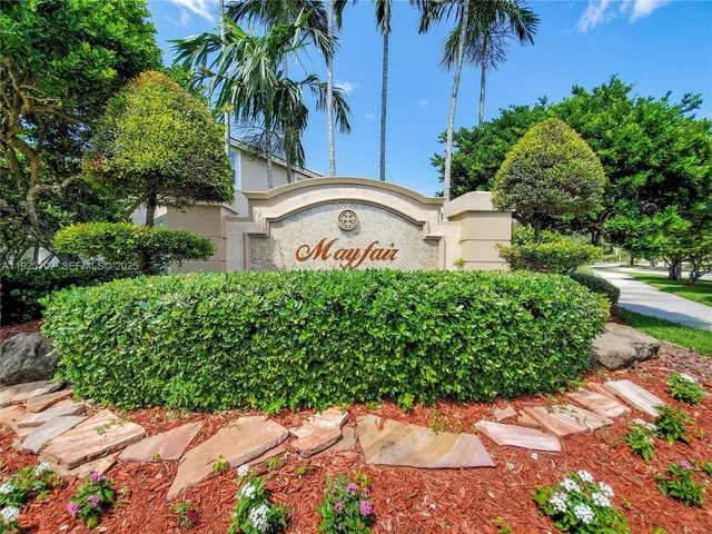 a front view of a house with a yard and potted plants