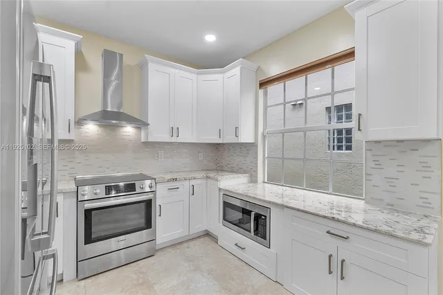 a kitchen with white cabinets and white appliances