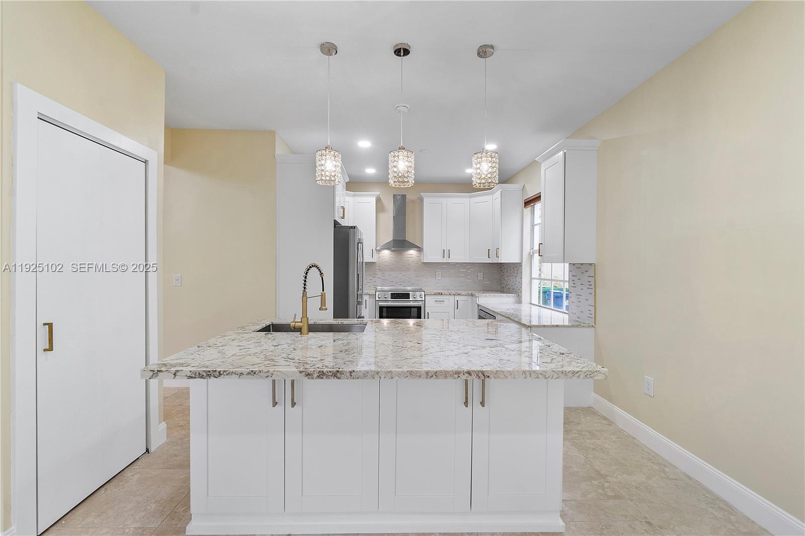 5310 Northwest 124th Way Coral Springs, FL 33076 - Photo 5 of 30 a kitchen with kitchen island granite countertop a sink cabinets and stainless steel appliances
