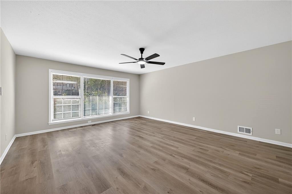 187 Old Timber Road Lawrenceville, GA 30046 - Photo 17 of 32 a view of a livingroom with wooden floor and a ceiling fan