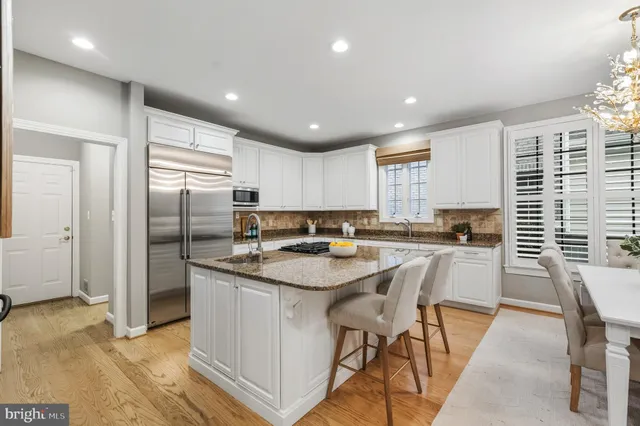 a large kitchen with stainless steel appliances granite countertop a stove a sink and a refrigerator