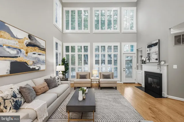 a living room with furniture a fireplace and a chandelier
