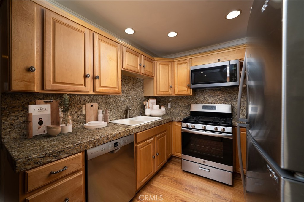 155 Oxford, Unit 37 Irvine, CA 92612 - Photo 3 of 33 a kitchen with stainless steel appliances granite countertop a stove a sink and a microwave