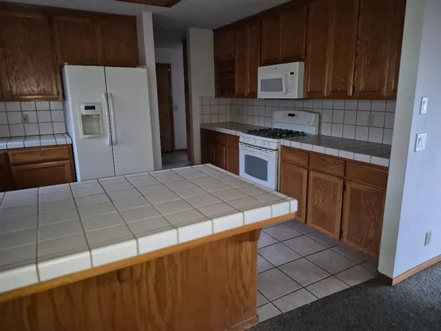 a kitchen with stainless steel appliances a sink a stove a refrigerator a microwave a sink and cabinets