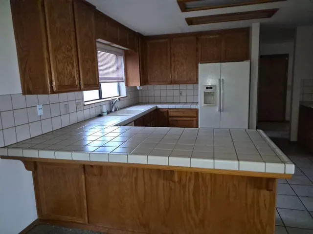 a kitchen with kitchen island a sink a counter top space and cabinets