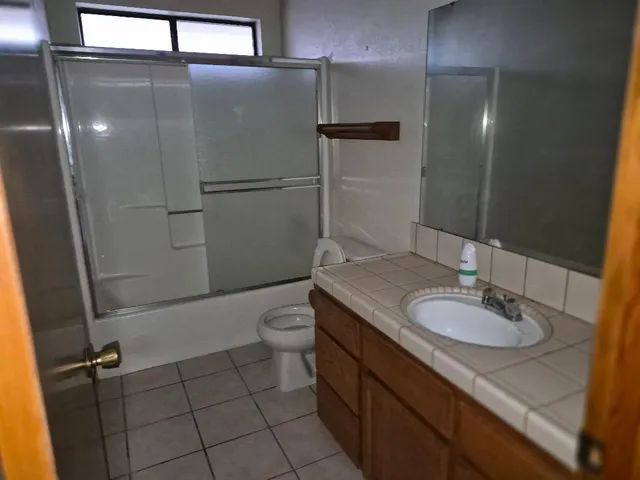 a bathroom with a granite countertop sink toilet and shower