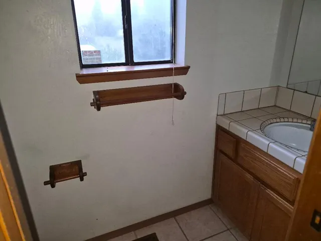 a bathroom with a granite countertop sink and a mirror