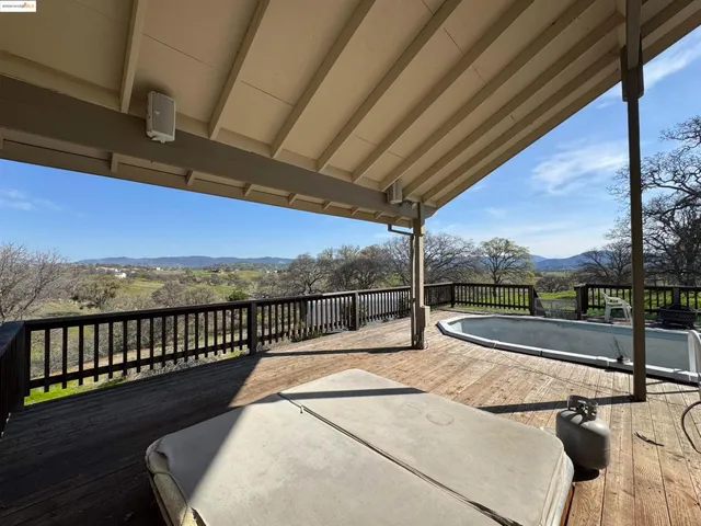 a view of a balcony with mountain view and wooden floor