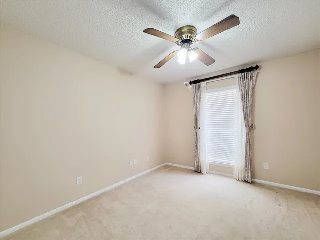 an empty room with a fan and a fan
