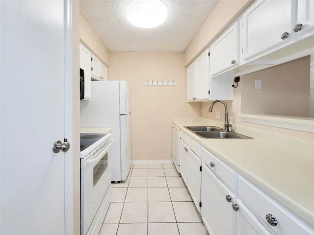 a kitchen with white cabinets and white appliances