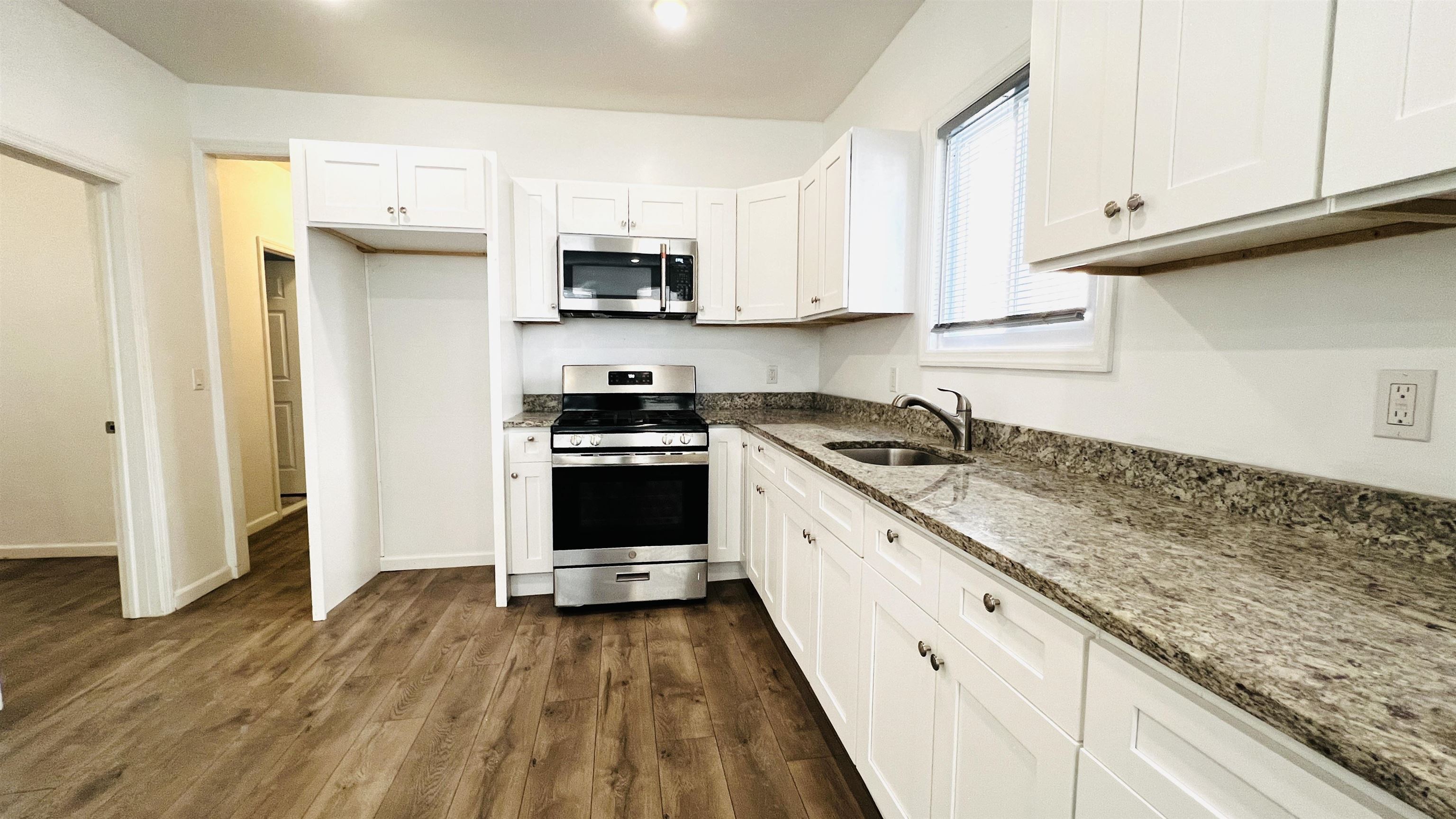 473 Grove Street, Unit 1 Irvington, NJ 07111 - Photo 4 of 9 a kitchen with stainless steel appliances granite countertop a sink and a stove