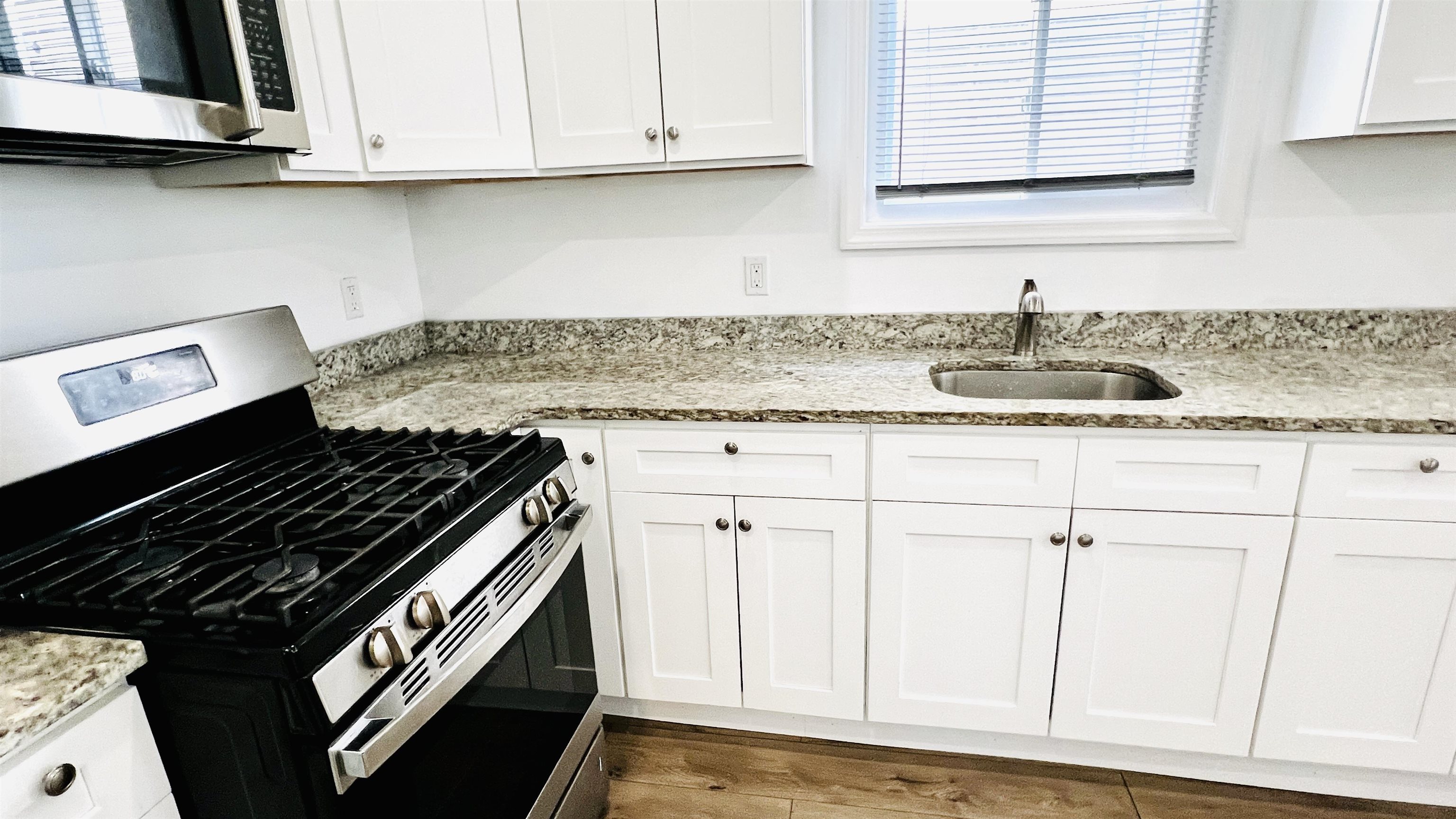 473 Grove Street, Unit 1 Irvington, NJ 07111 - Photo 5 of 9 a kitchen with granite countertop white cabinets and a stove