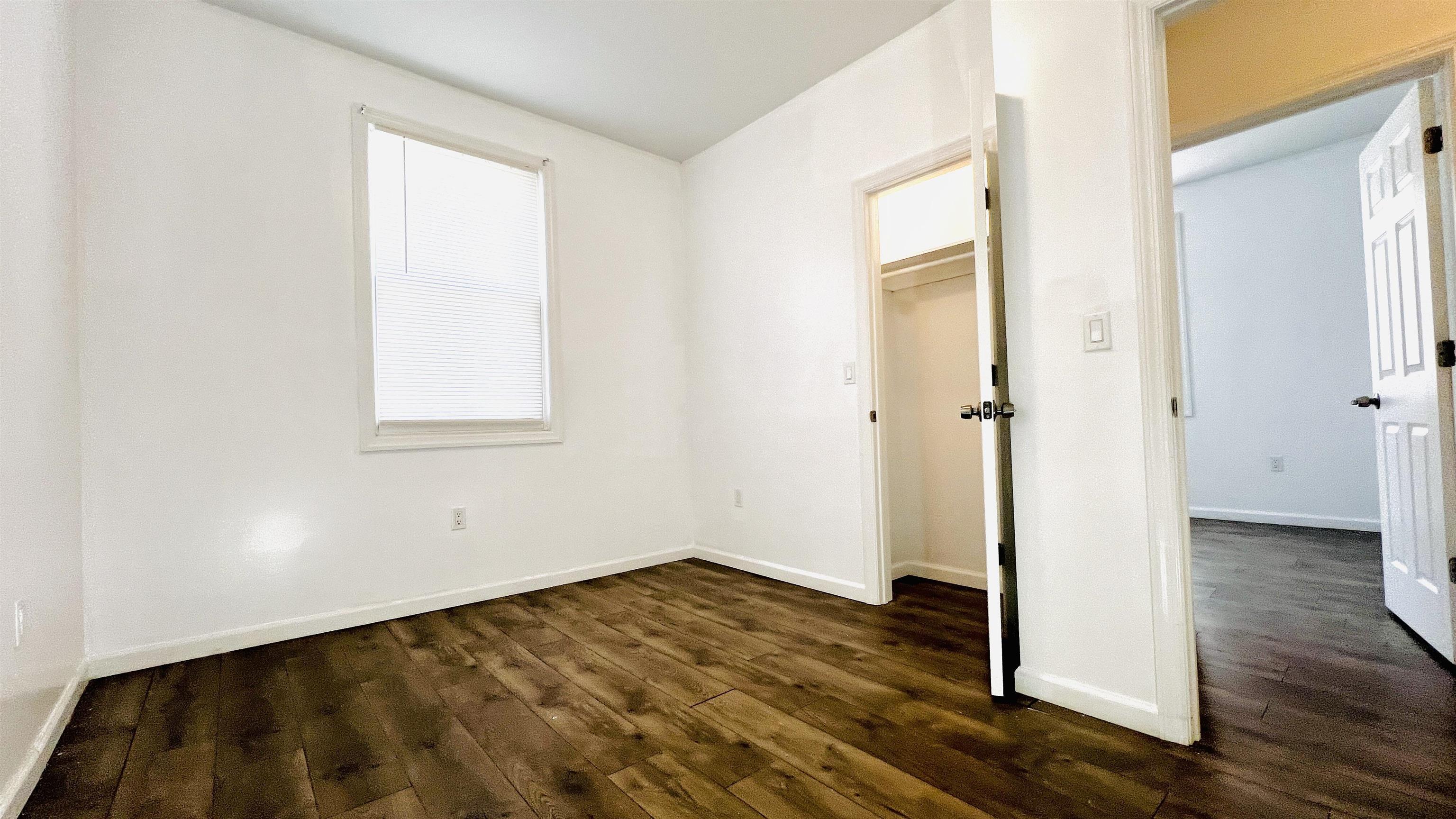 473 Grove Street, Unit 1 Irvington, NJ 07111 - Photo 8 of 9 an empty room with wooden floor and a window