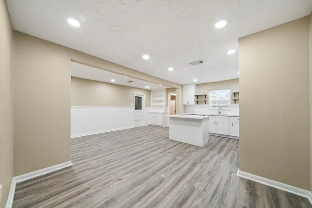 a view of a kitchen with wooden floor and a sink