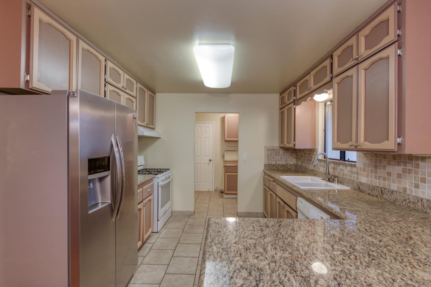 42607 Long Hollow Drive Coarsegold, CA 93614 - Photo 25 of 52 a kitchen with a refrigerator sink and cabinets