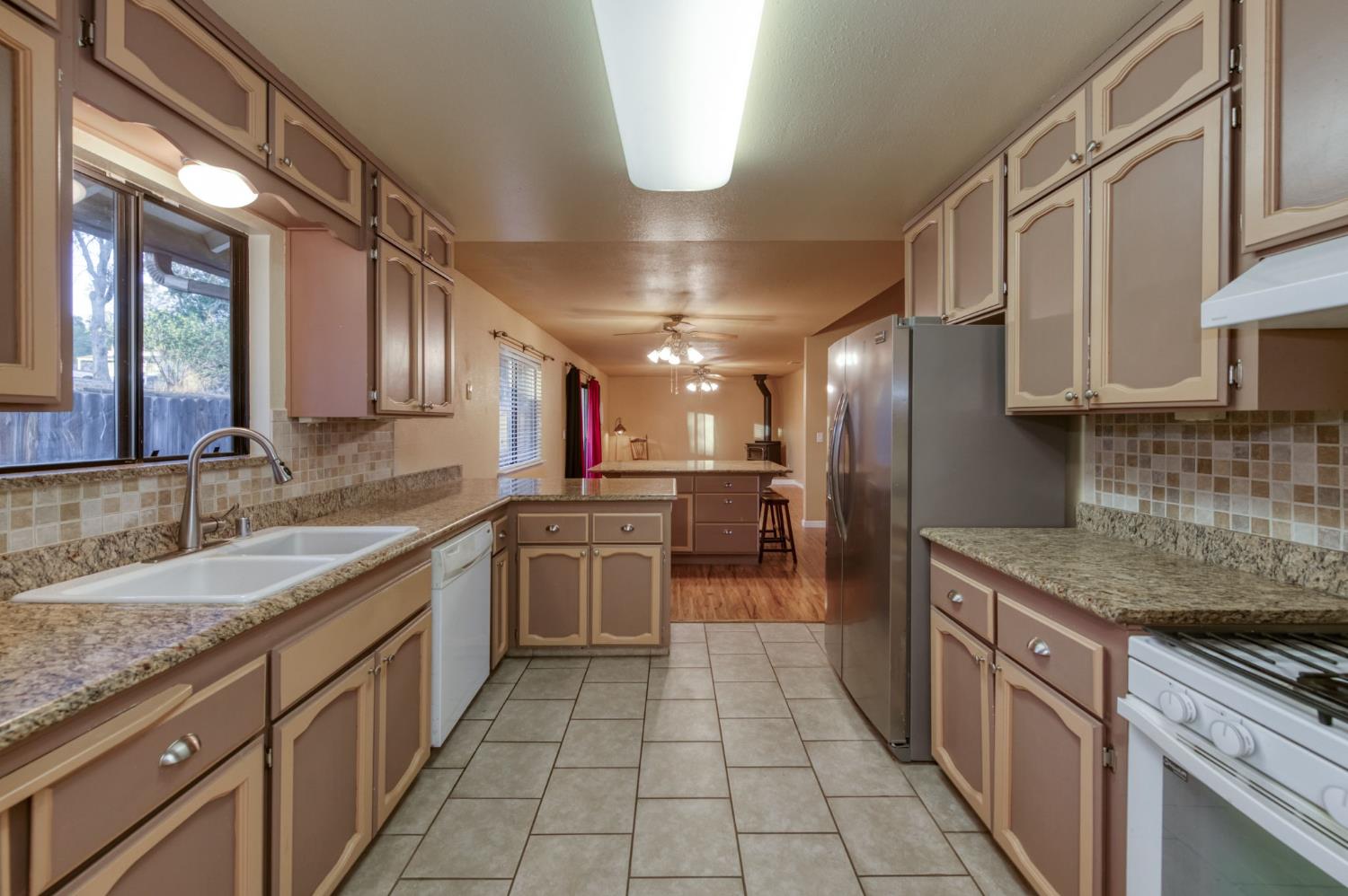 42607 Long Hollow Drive Coarsegold, CA 93614 - Photo 27 of 52 a kitchen with stainless steel appliances granite countertop a sink counter space cabinets and a large window