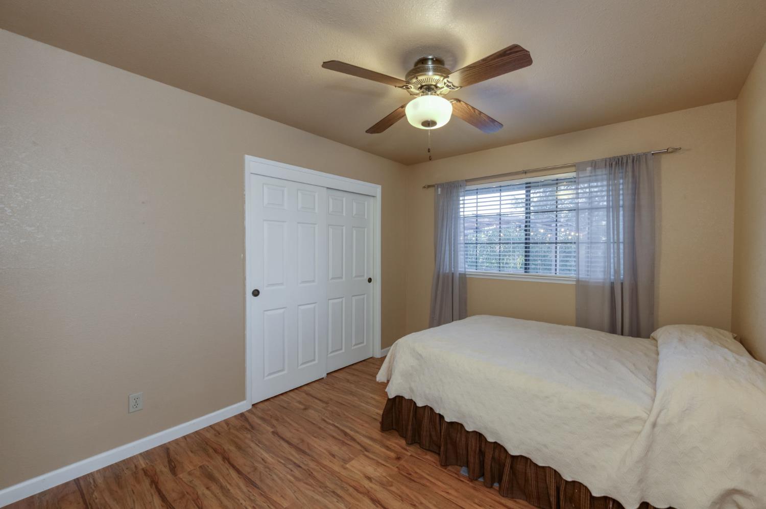 42607 Long Hollow Drive Coarsegold, CA 93614 - Photo 4 of 52 a bedroom with a large bed and a chandelier