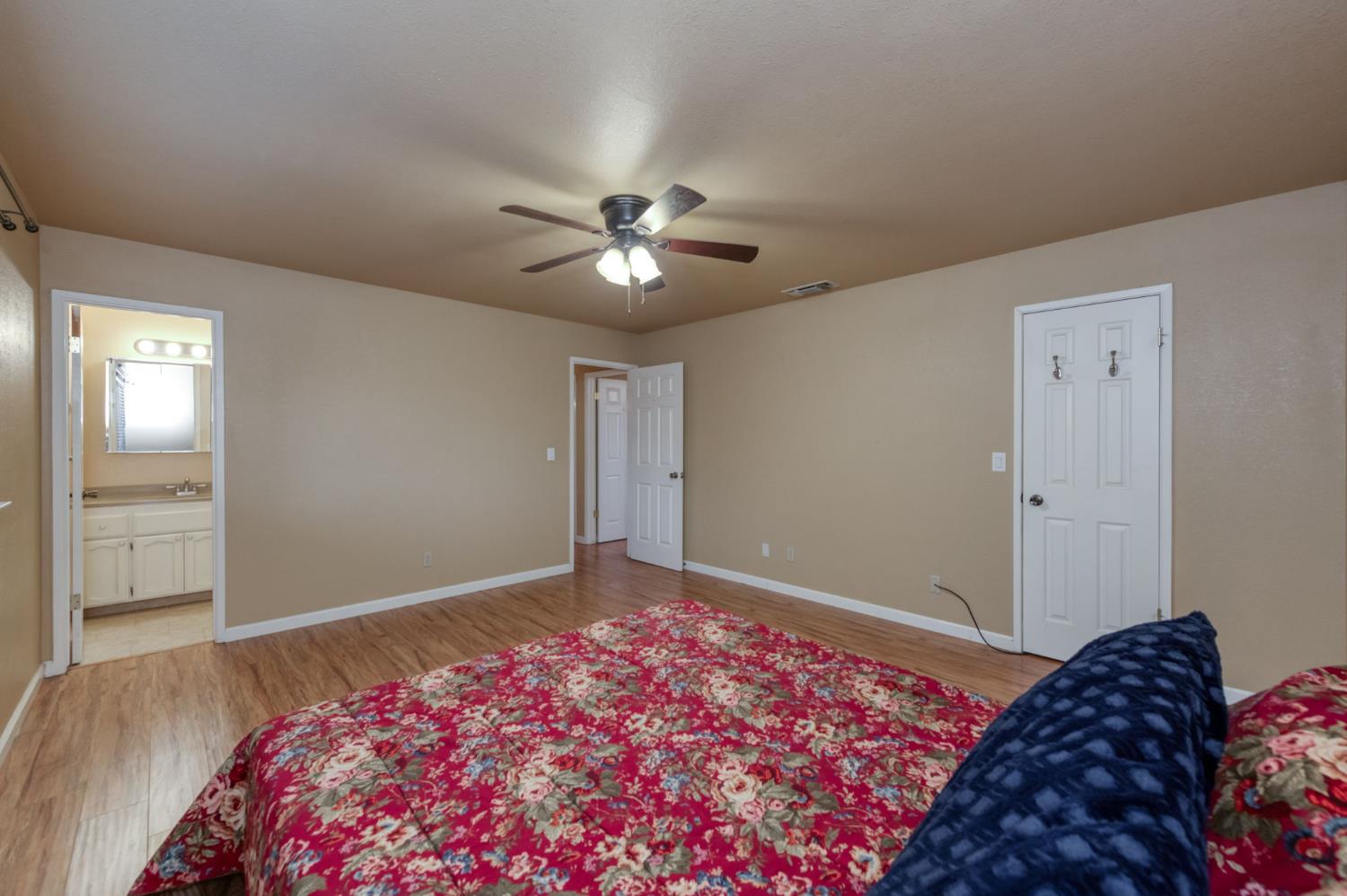 42607 Long Hollow Drive Coarsegold, CA 93614 - Photo 7 of 52 a bedroom with bed and a chandelier fan
