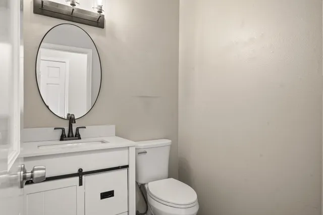 a bathroom with a toilet a sink and a mirror