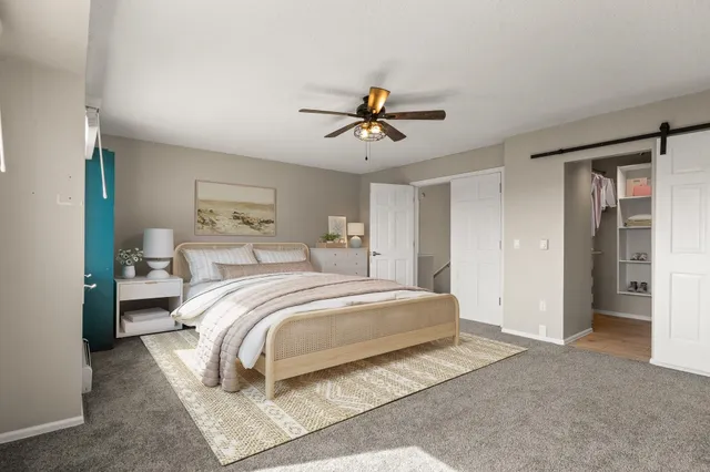 a bedroom with a large bed and ceiling fan