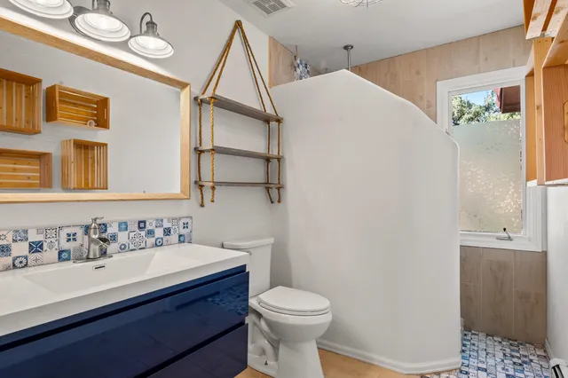 a bathroom with a sink a toilet and shower