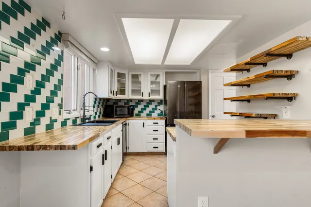 a kitchen with granite countertop a sink and cabinets