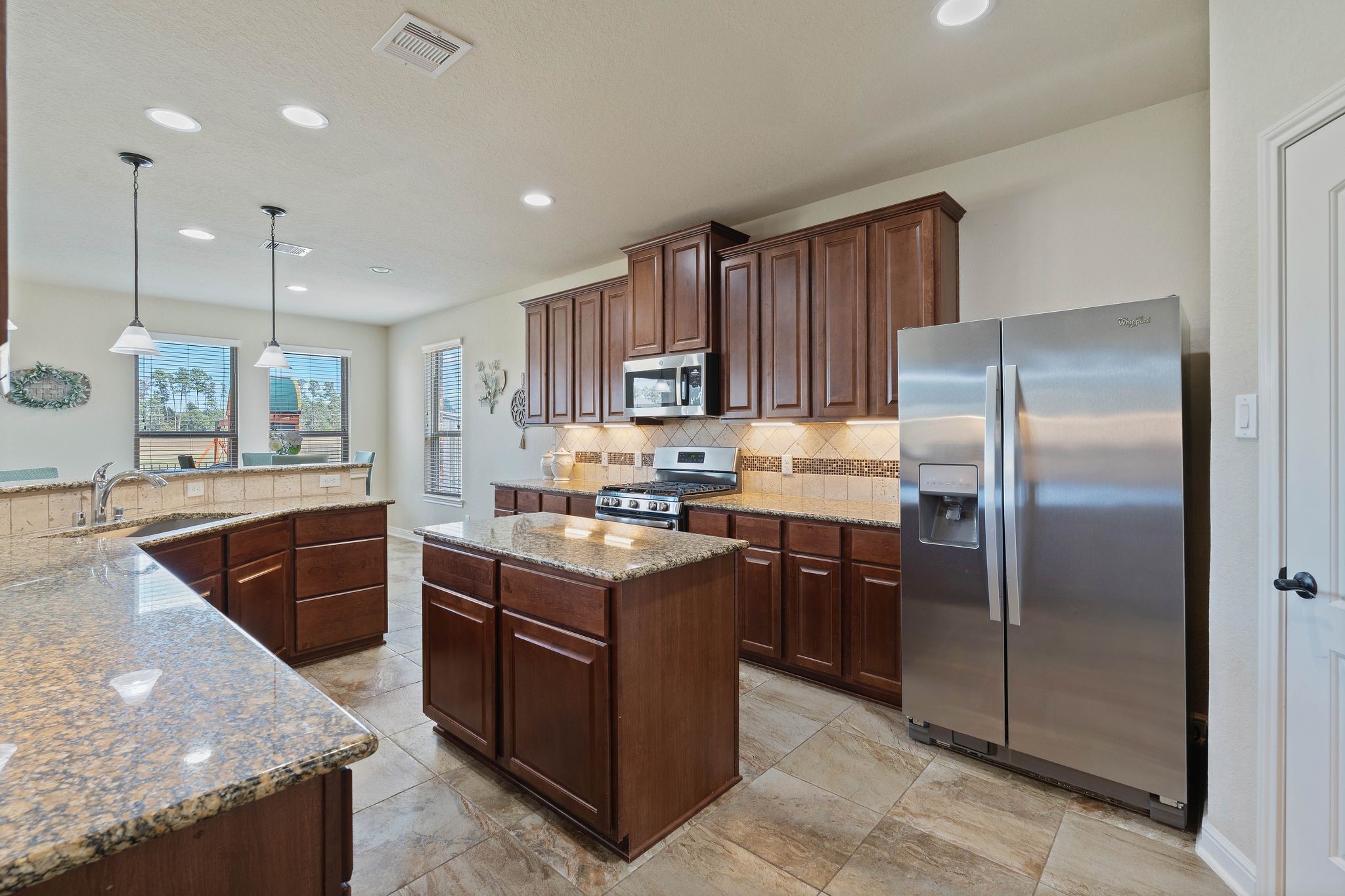 10114 North Whimbrel Circle Conroe, TX 77385 - Photo 17 of 50 a kitchen with stainless steel appliances granite countertop a stove a sink dishwasher a refrigerator and a oven