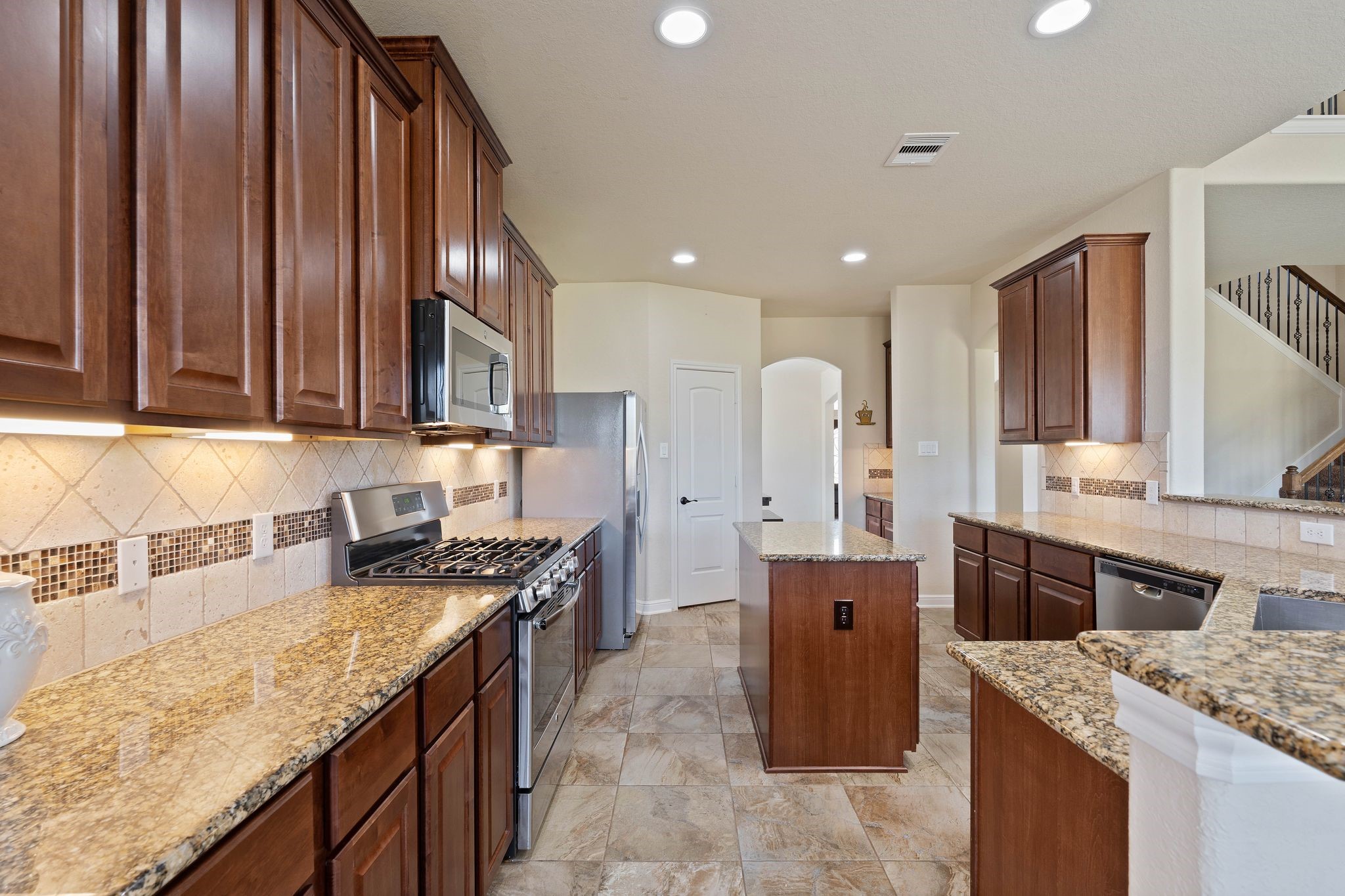 10114 North Whimbrel Circle Conroe, TX 77385 - Photo 18 of 50 a kitchen with a stove top oven sink and cabinets