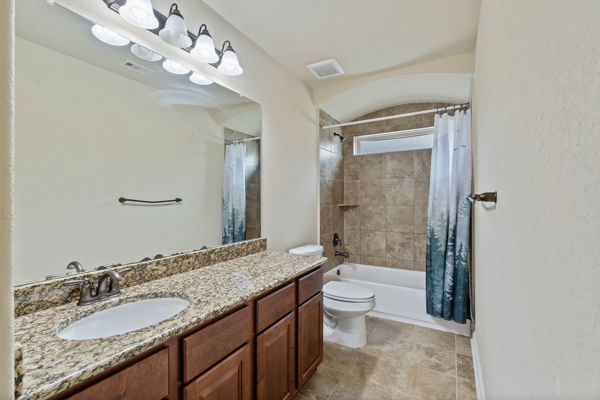 10114 North Whimbrel Circle Conroe, TX 77385 - Photo 33 of 50 a bathroom with a granite countertop sink a toilet a mirror and bathtub