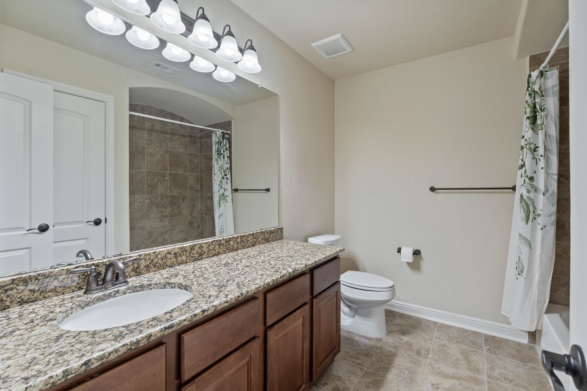10114 North Whimbrel Circle Conroe, TX 77385 - Photo 40 of 50 a bathroom with a granite countertop sink a toilet and a mirror