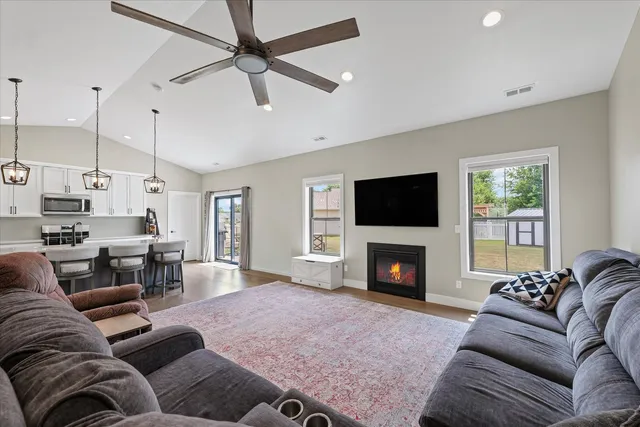 a living room with furniture a fireplace and a flat screen tv