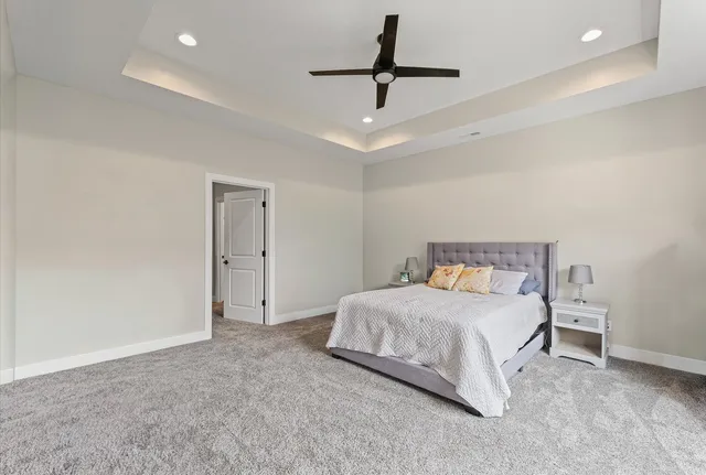 a bedroom with a bed and a ceiling fan