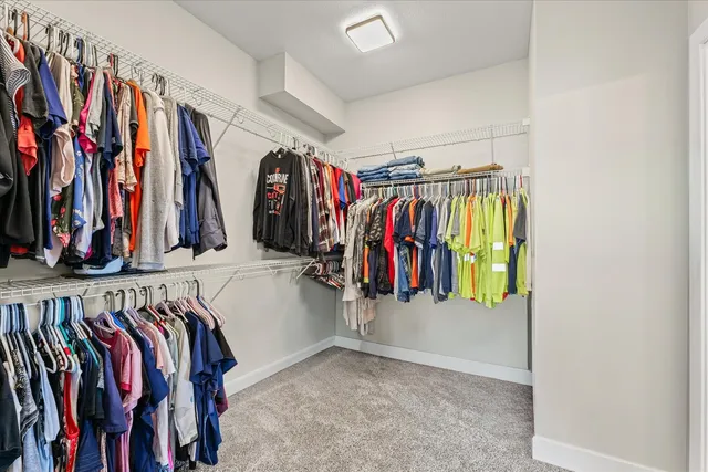 a view of walk in closet with clothes