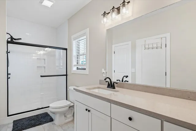 a bathroom with a sink a toilet and shower