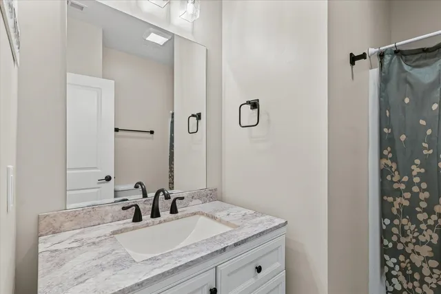 a bathroom with a granite countertop sink and a mirror