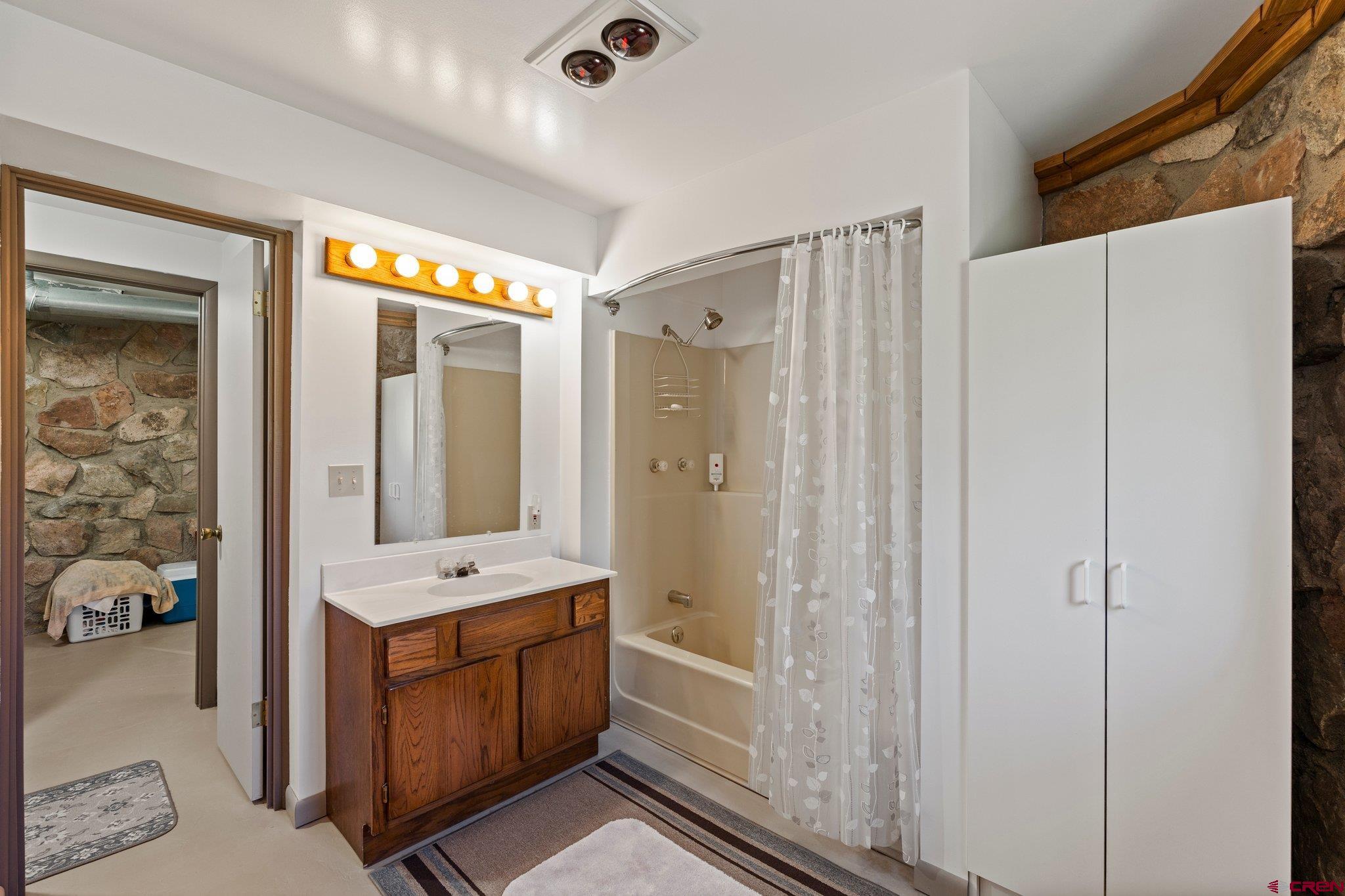 1389 County Road 240 Durango, CO 81301 - Photo 31 of 35 a bathroom with a double vanity sink a mirror and a bathtub
