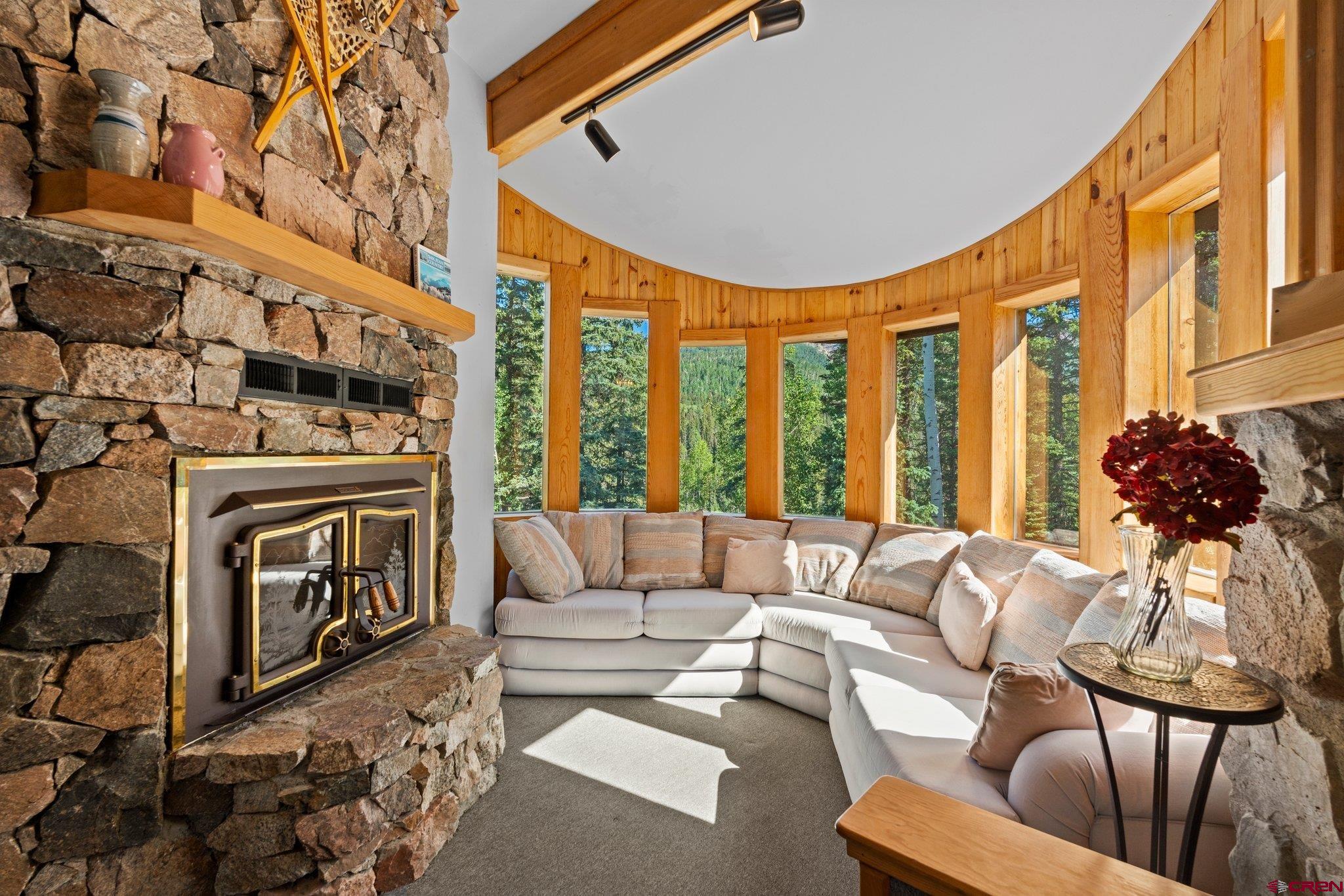1389 County Road 240 Durango, CO 81301 - Photo 5 of 35 a living room with furniture a fireplace and a chandelier
