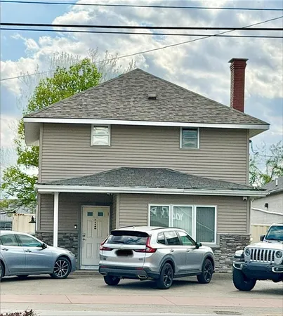 a couple of cars parked in front of a house