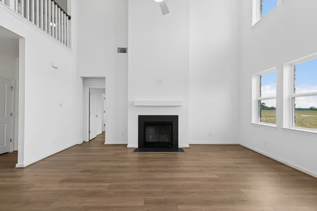 wooden floor fireplace and windows in an empty room