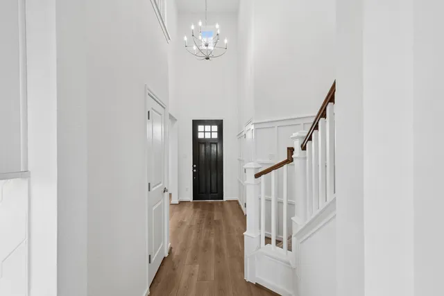 a view of a hallway with wooden floor and staircase
