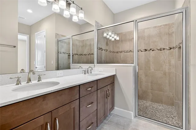 a bathroom with a double vanity sink mirror and shower