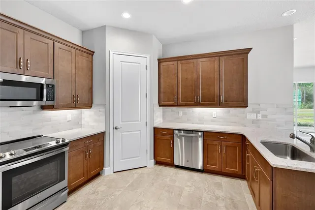 a kitchen with stainless steel appliances granite countertop a sink stove and refrigerator