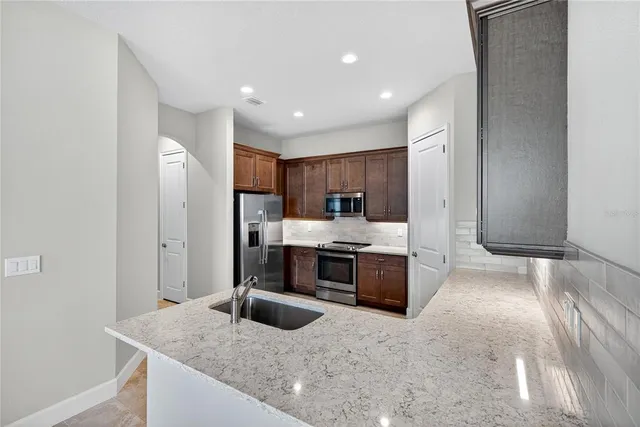 a kitchen with stainless steel appliances granite countertop a sink stove and refrigerator