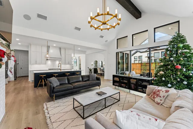 a living room with furniture a flat screen tv and a chandelier