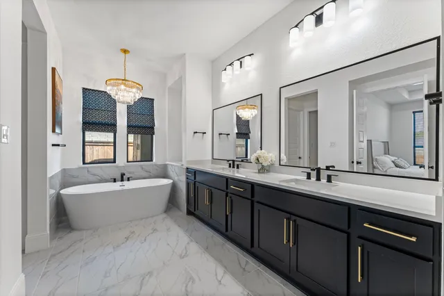a spacious bathroom with a double vanity sink mirror and bathtub
