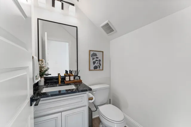 a bathroom with a toilet a sink and mirror