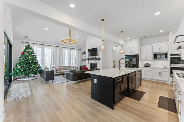 a kitchen with kitchen island a large counter top space a sink stainless steel appliances and cabinets