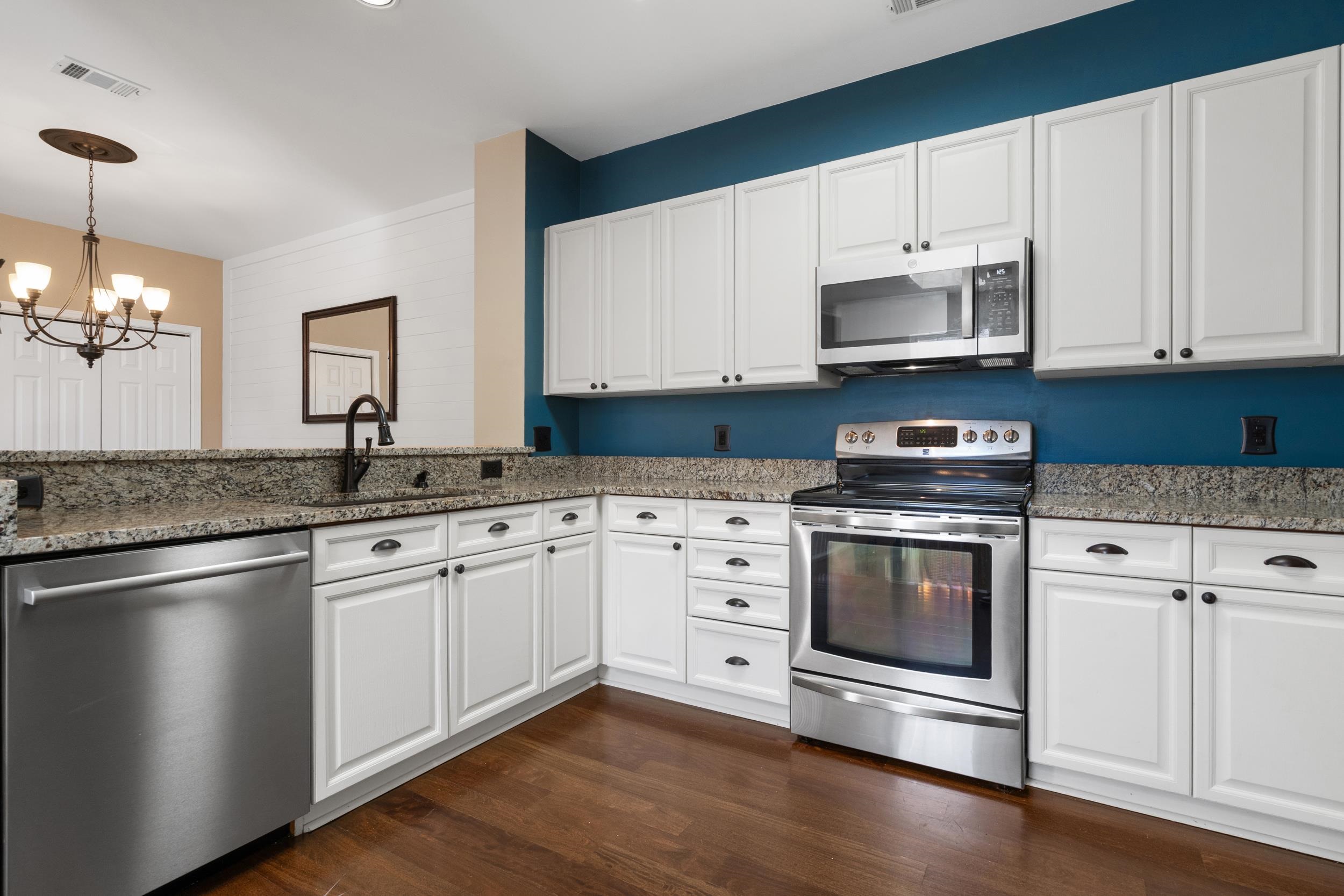 4436 Lady Banks Lane, Unit B2 Murrells Inlet, SC 29576 - Photo 11 of 36 Kitchen featuring stainless steel appliances, white cabinets, light stone countertops, a chandelier, and pendant lighting