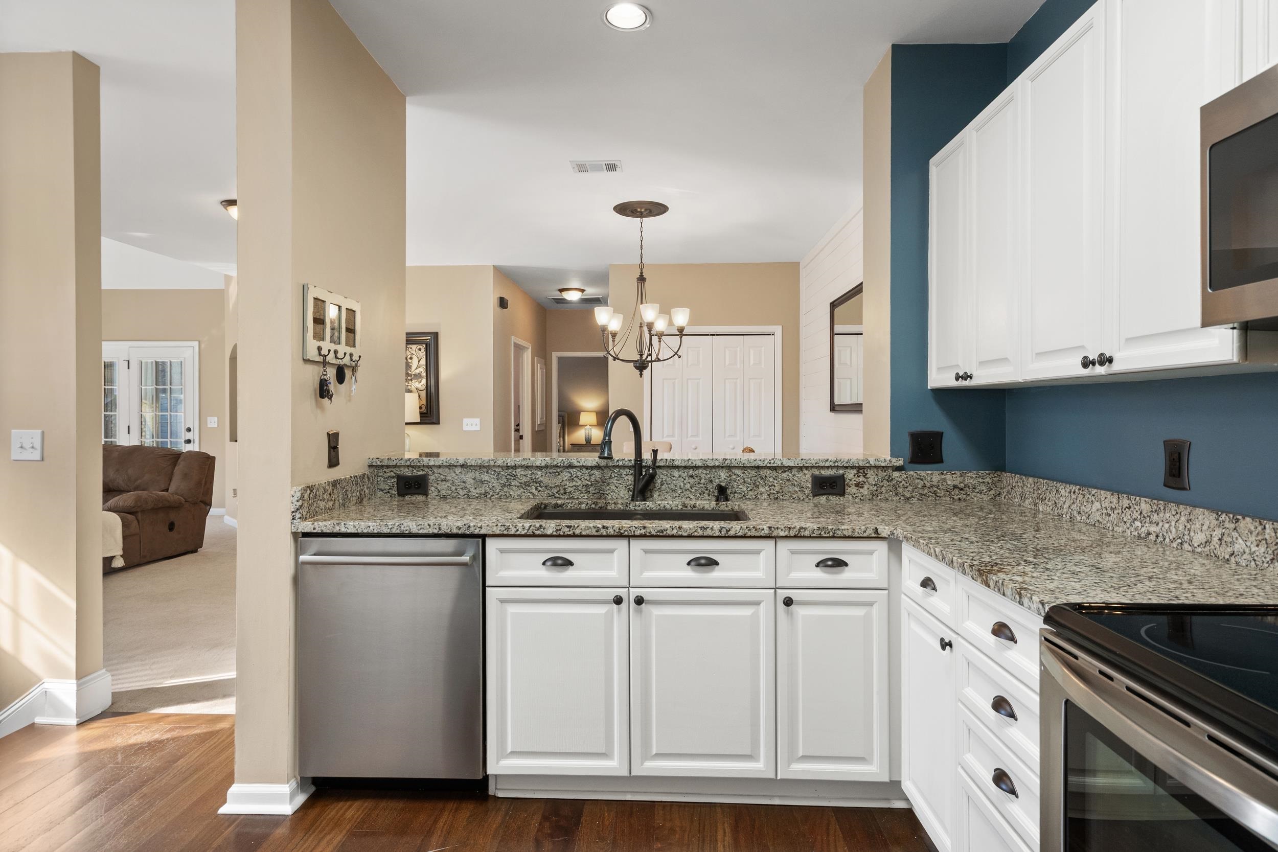 4436 Lady Banks Lane, Unit B2 Murrells Inlet, SC 29576 - Photo 12 of 36 Kitchen with light stone counters, white cabinets, stainless steel appliances, and a chandelier